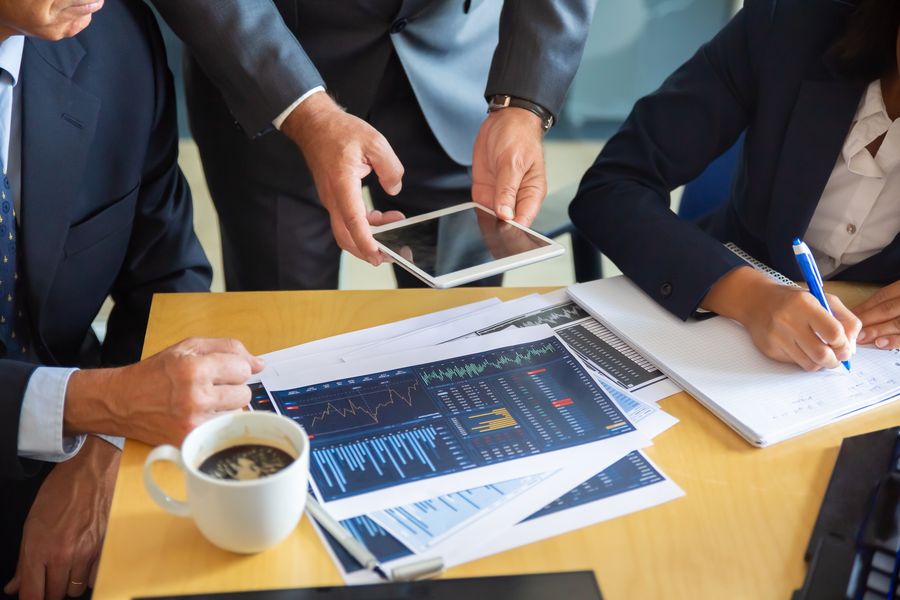 Advisers reviewing investment charts around a table